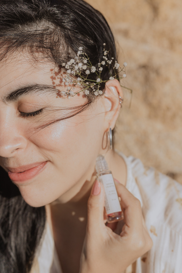 Woman Applying Perfume with a Roller Bottles